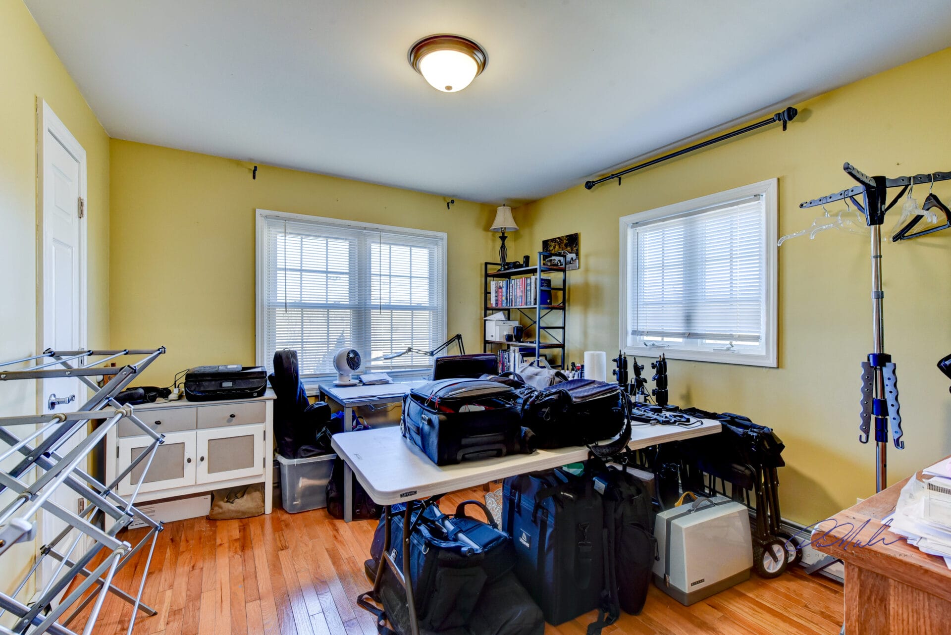 Cluttered room filled with equipment and personal items not prepared for real estate photography