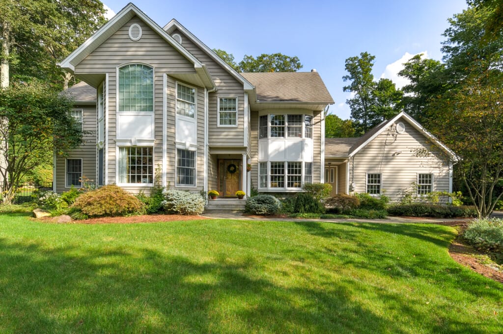 Luxury home exterior in Morris County NJ with manicured lawn, landscaping, and traditional architecture