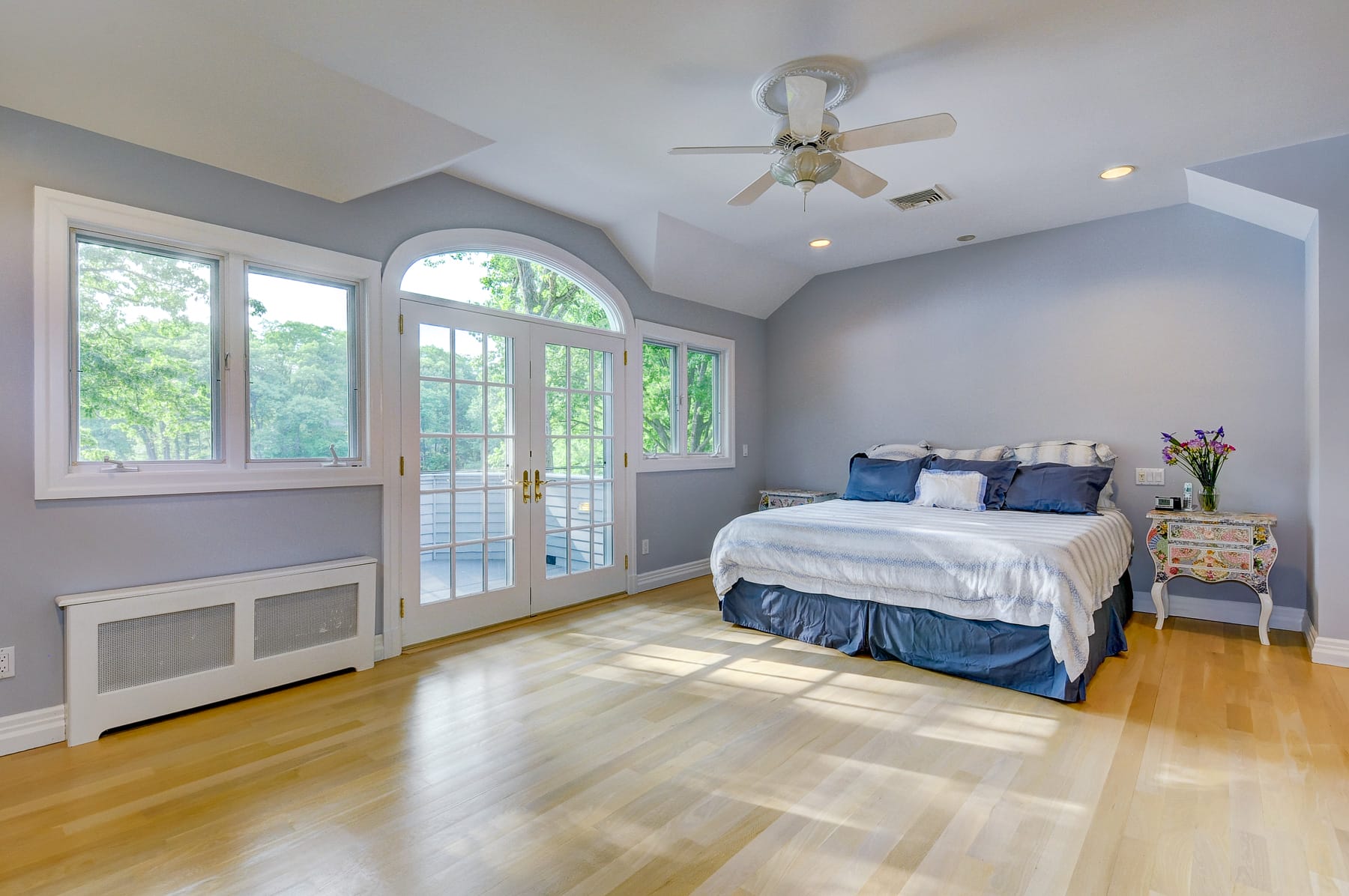 Primary bedroom in Morris County NJ with vaulted ceiling, French doors, large windows, and natural light