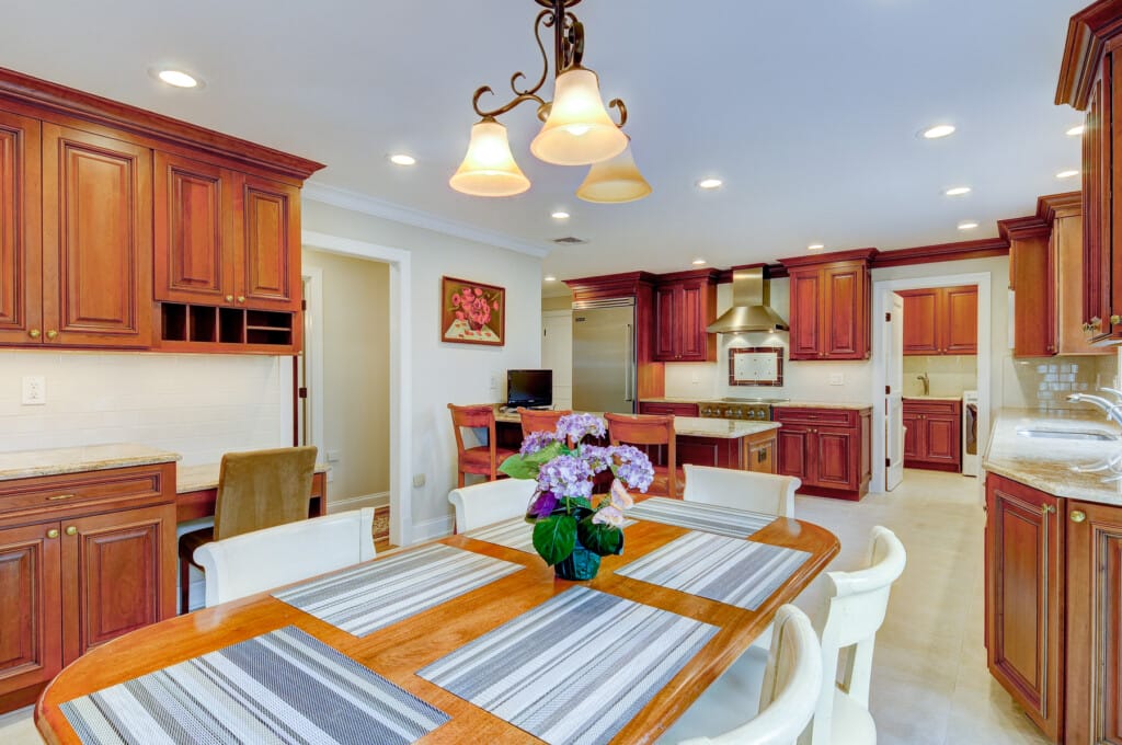 Kitchen and everyday dining area in Morris County NJ with wood cabinetry, breakfast table, and built-in workspace