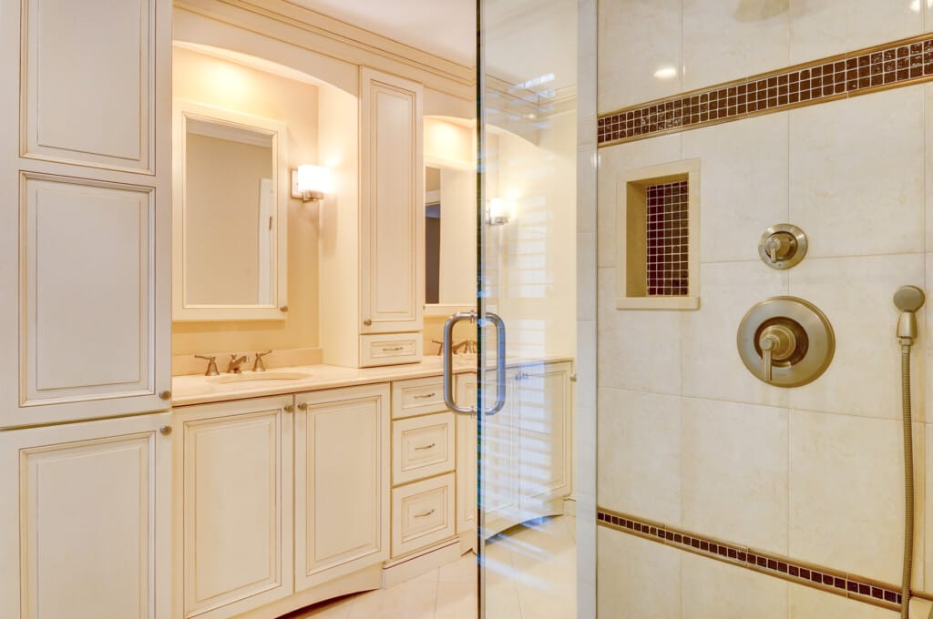 Primary bathroom in Morris County NJ with glass shower, custom vanity, and neutral tile finishes