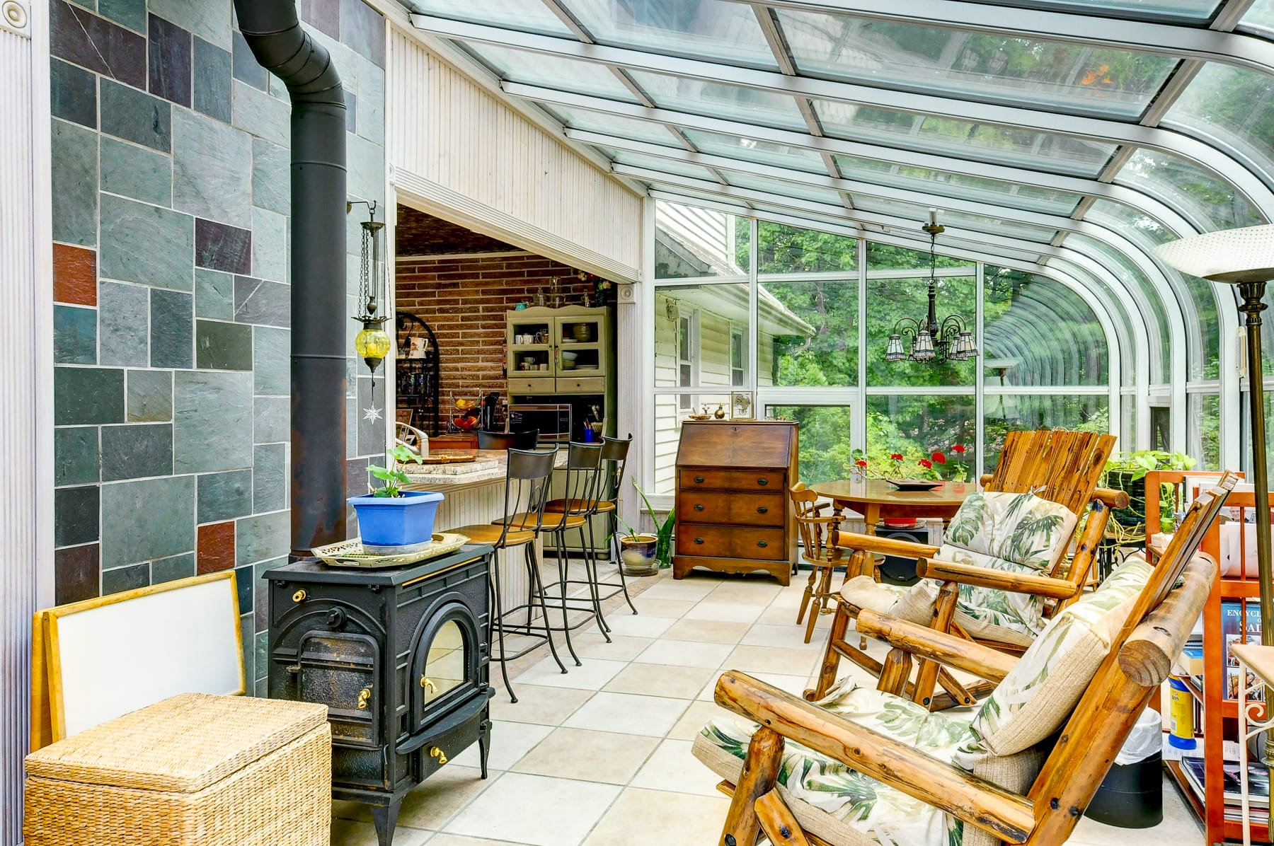 Glass sunroom in Morris County NJ with enclosed patio seating, wood stove, and natural light